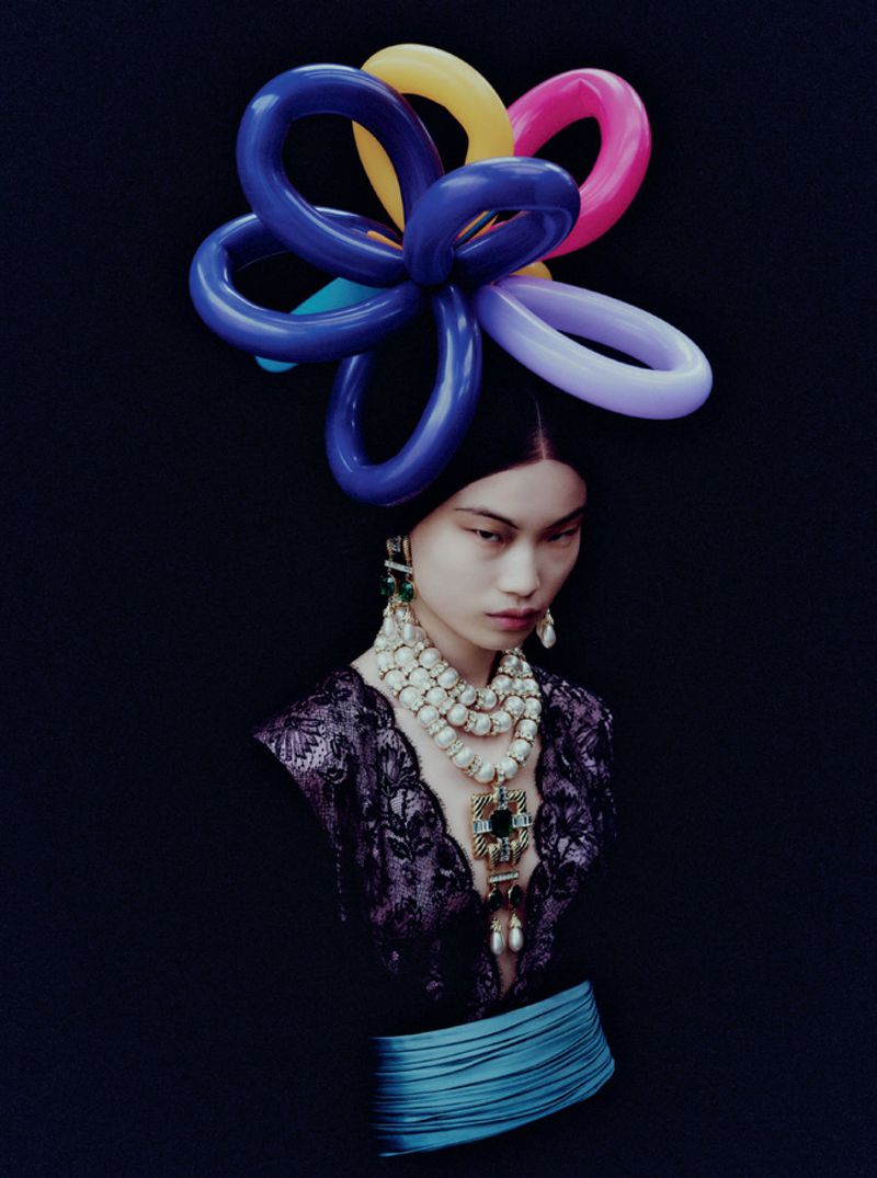 Model wearing elaborate pearl necklaces and a colourful balloon headpiece against a dark background for Mixte