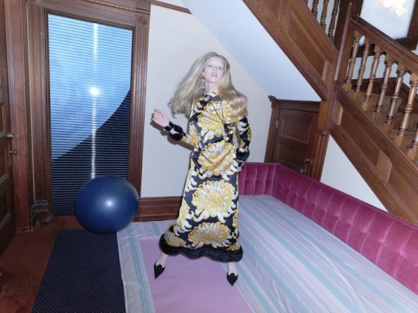 Model Abby Champion wearing a long patterned dress in a wood-trimmed interior by Jumbo Tsui for Rouge Fashionbook.