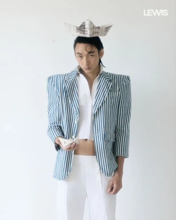 Man wearing a blue-and-white striped blazer, white shirt, and paper boat hat for Lewis Magazine project LIFE’s A JOURNEY