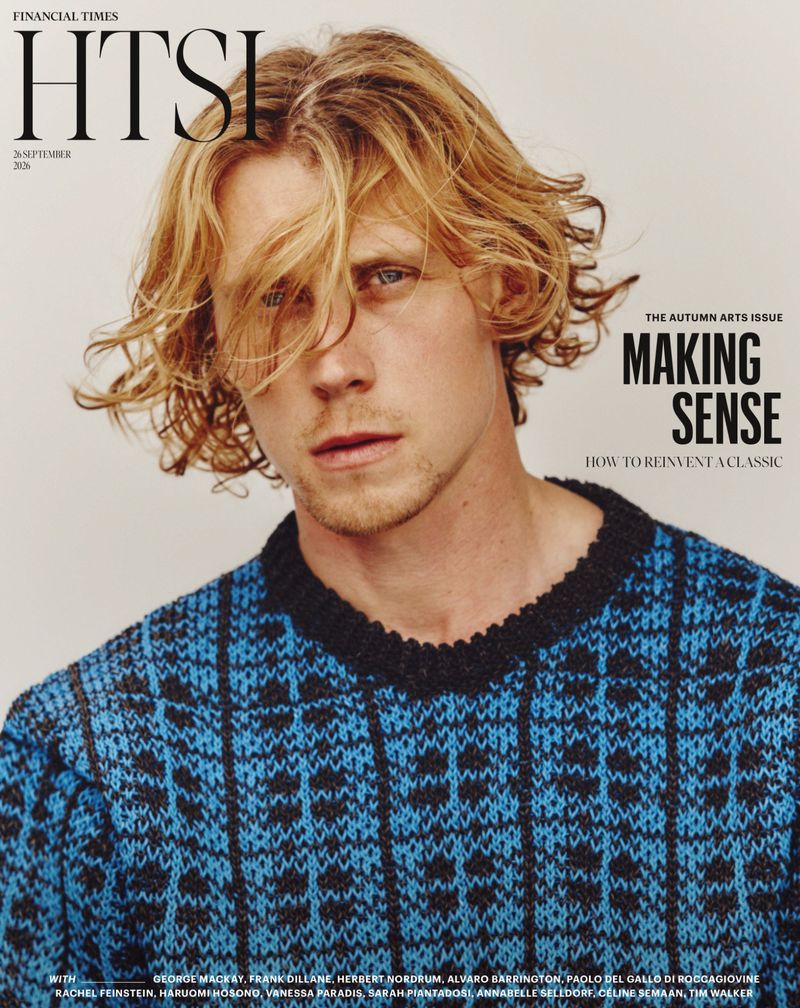 Portrait of actor George MacKay wearing a blue patterned knit sweater against a plain neutral background for Financial Times HTSI Magazine.