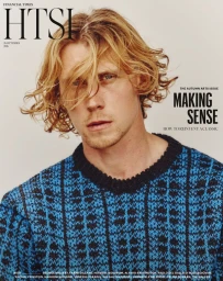 Portrait of actor George MacKay wearing a blue patterned knit sweater against a plain neutral background for Financial Times HTSI Magazine.