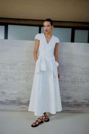 Model Lara Menezes wearing a white cap-sleeve maxi dress and black strappy sandals for the ME+EM June Lookbook