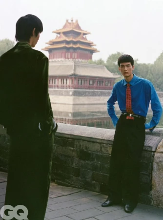 Two male models posing near a historic traditional pavilion with a stone wall in GQ China editorial photography.