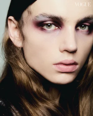 Close-up beauty portrait of a model with dramatic plum eyeshadow and pale pink lips for Vogue Brasil shot by Jonathan Wolpert.