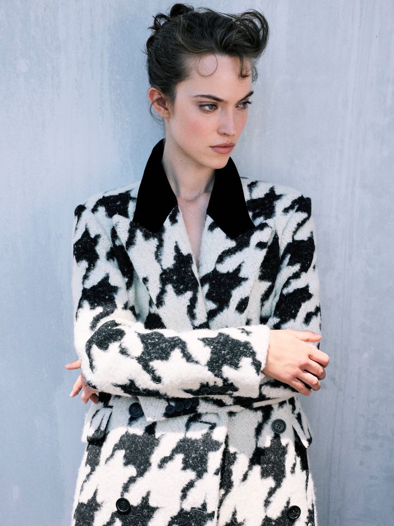 Model Caro Casay wearing a black and white patterned coat against a grey wall for Harper's Bazaar Turkey