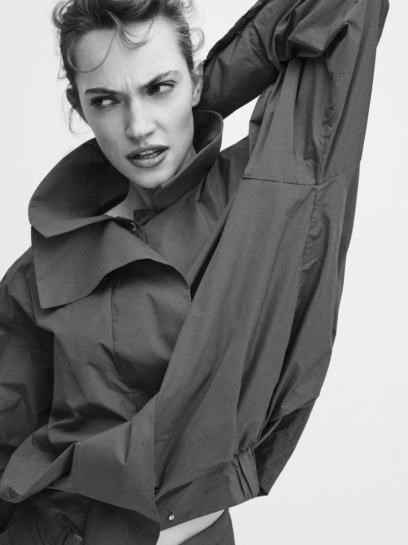 Model Caro Casay in a high-collared dark top with her arm raised against a plain white background for Harper's Bazaar Turkey.