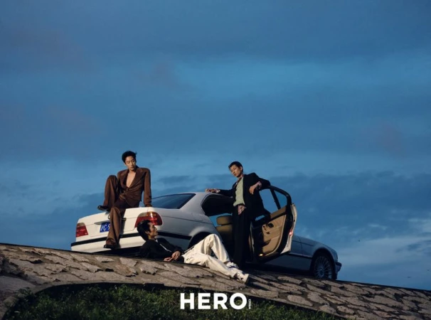 Three male models posing with a white sedan against a twilight sky for HERO Magazine.