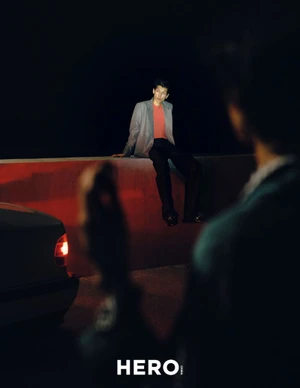Model seated on a ledge at night with red and dark lighting for HERO Magazine editorial Summer’s Last Hurrah