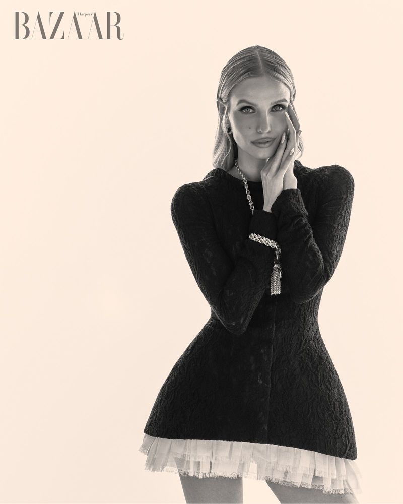 Leonie Hanne in a black textured dress with a white ruffled hem against a pale background for Harper's Bazaar Vietnam.