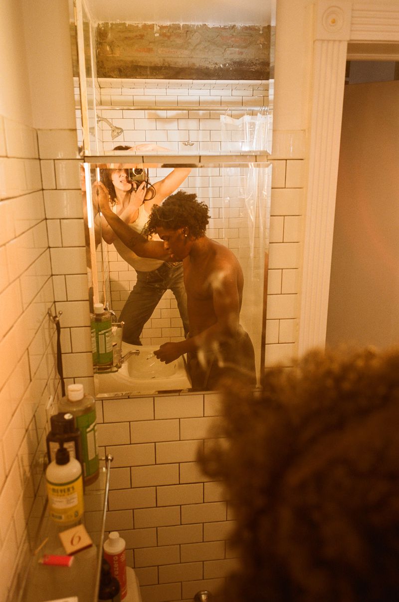A man in a bathroom mirror reflection, captured for Interlope Magazine by Elena Mottola.