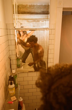 A man in a bathroom mirror reflection, captured for Interlope Magazine by Elena Mottola.
