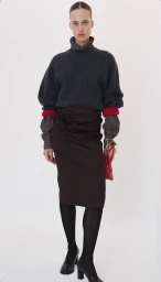 Model wearing dark grey sweater, brown skirt, and black tights against white background for Recto fall winter 2026