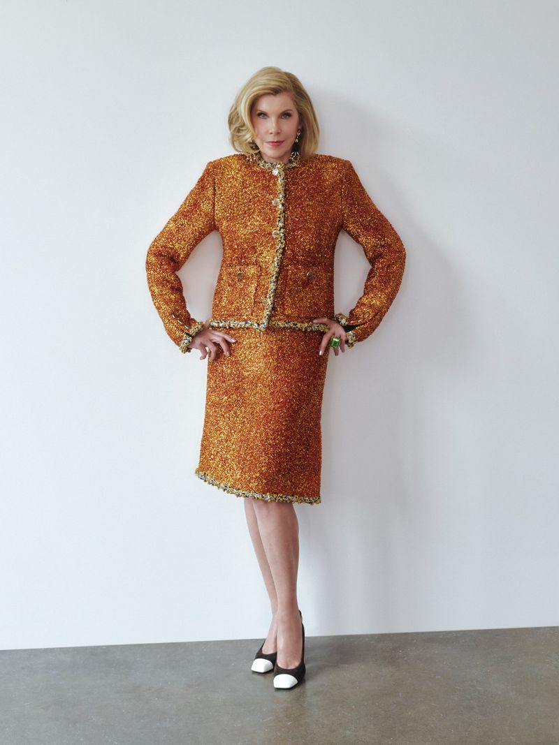 Christine Baranski posing in a textured tweed skirt suit against a plain white studio wall