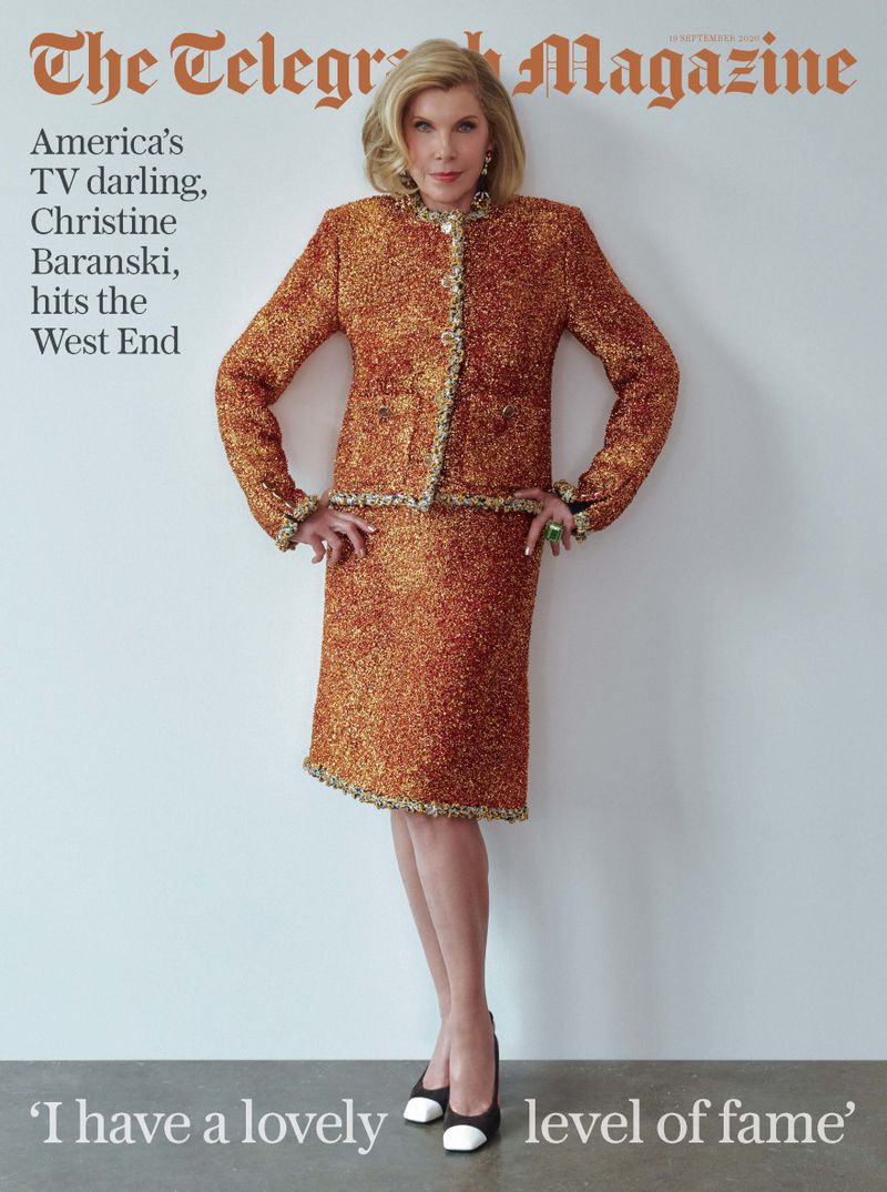 Christine Baranski wearing a metallic orange skirt suit against a plain white studio wall for Telegraph Magazine.