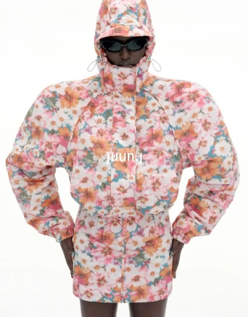 Model wearing floral print hooded jacket with padded shoulders and sunglasses against a plain white background for Juun.J S/S27