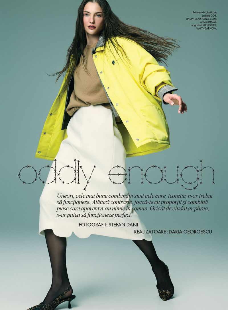 Model wearing a bright yellow jacket, beige sweater, and white skirt against a teal background for Elle Romania editorial