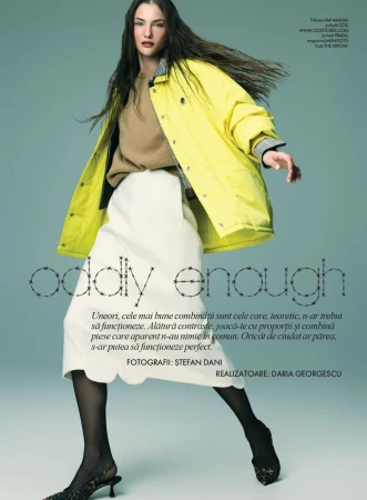 Model wearing a bright yellow jacket, beige sweater, and white skirt against a teal background for Elle Romania editorial