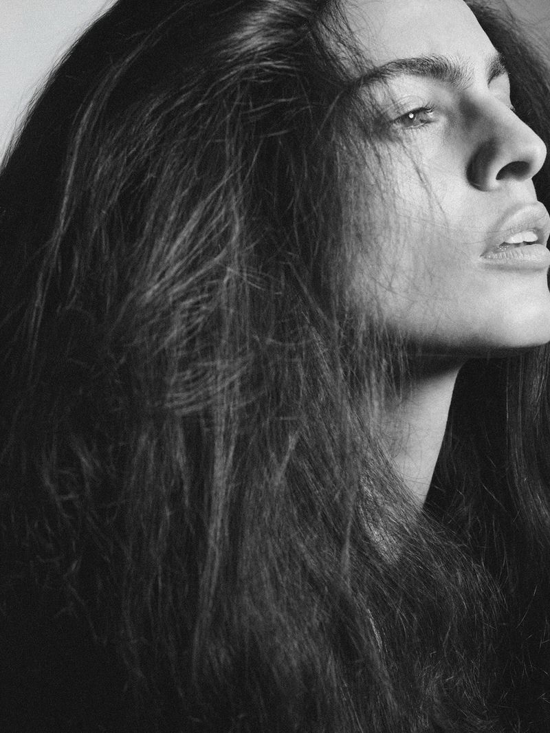 Monochrome portrait of a woman with long dark hair looking away in profile for i-D Magazine
