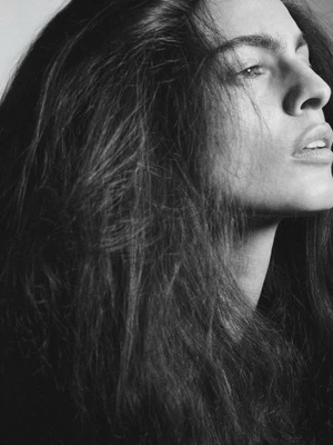 Monochrome portrait of a woman with long dark hair looking away in profile for i-D Magazine