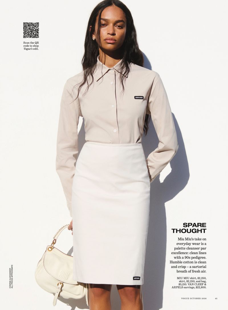 Model in cream button-up shirt and pencil skirt holding a white handbag against a plain white studio background.