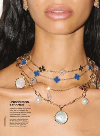 Close-up portrait of a model wearing layered gold pendant necklaces and matching earrings for Vogue Australia editorial.