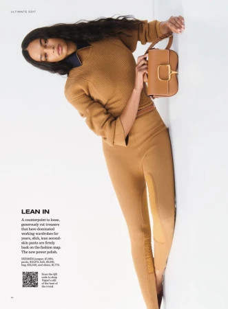 Model in brown ribbed jumper and trousers holding a brown leather handbag against a plain white background