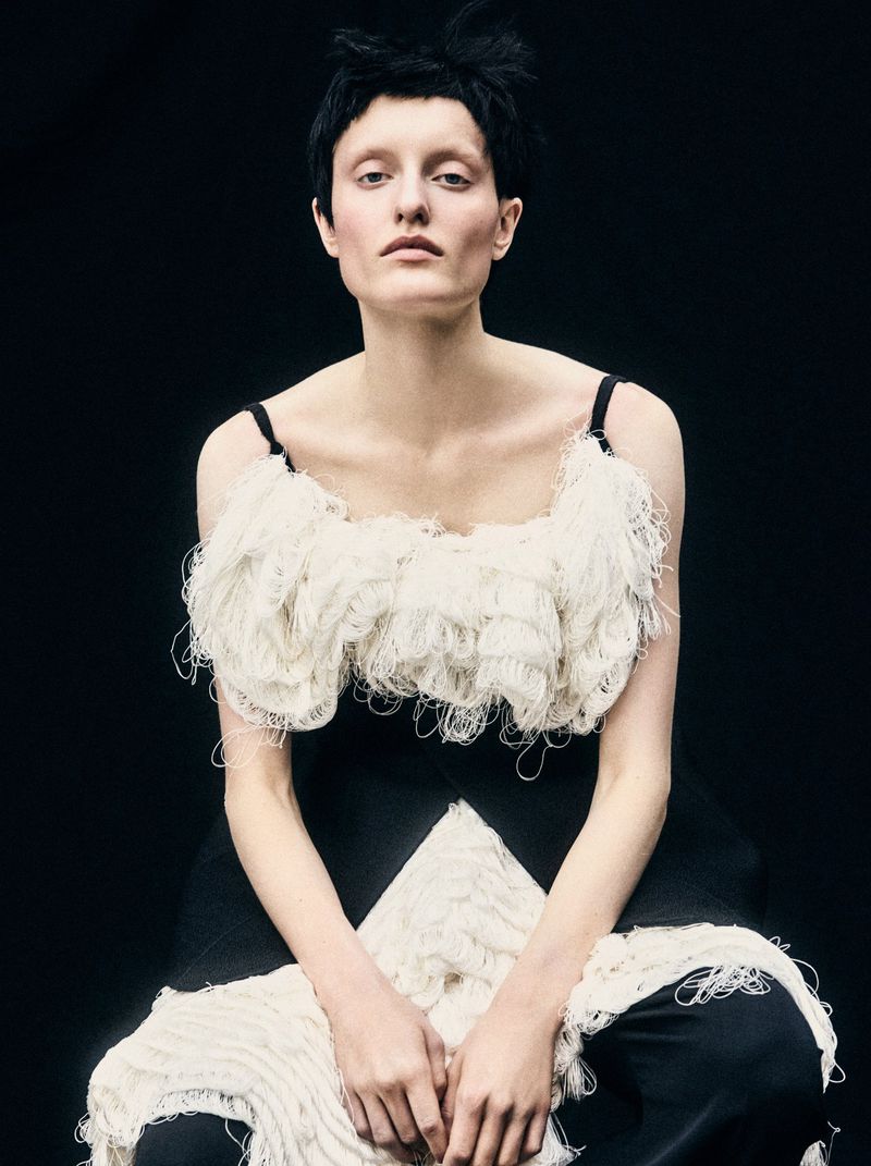 Model in textured white and black fringed garment against a dark background for Mixte project Perfect Strangers