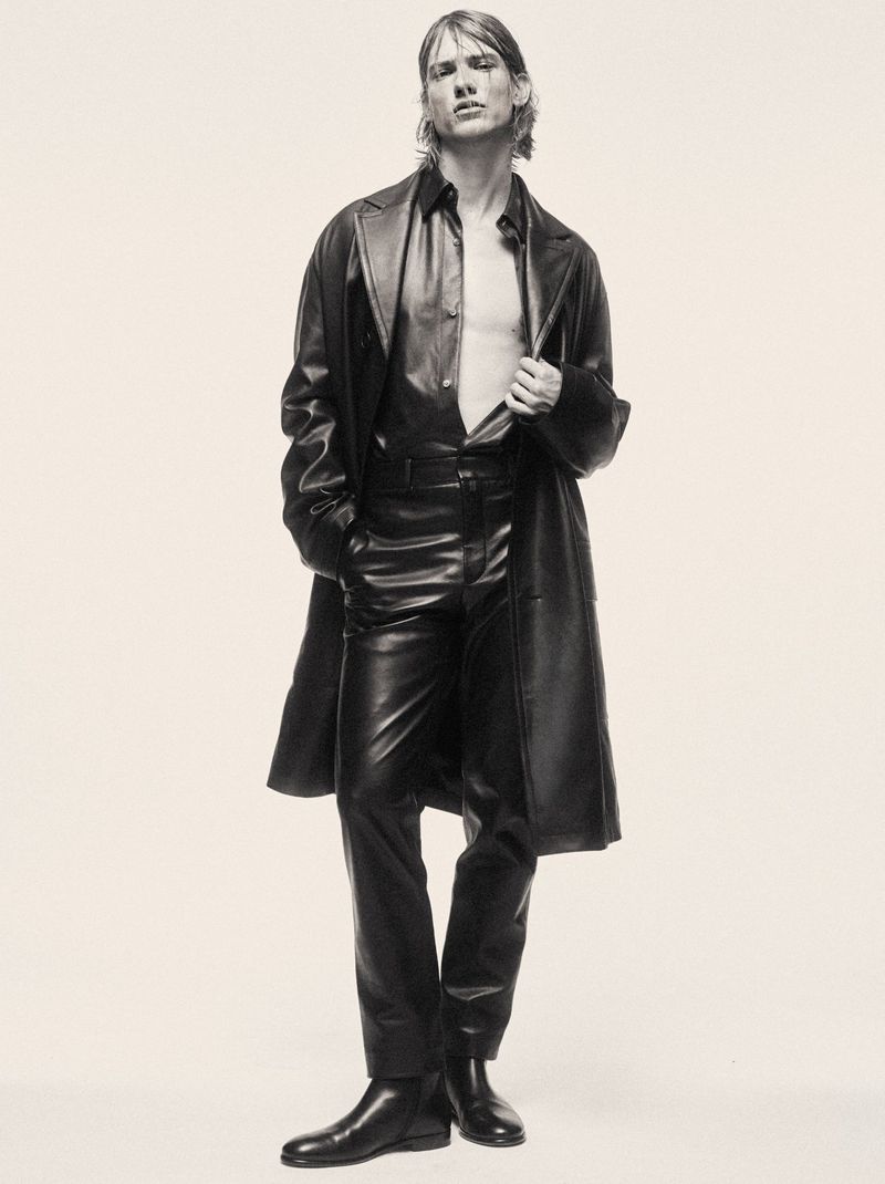 Model in black leather coat and trousers against a pale background for the Mixte Perfect Strangers project