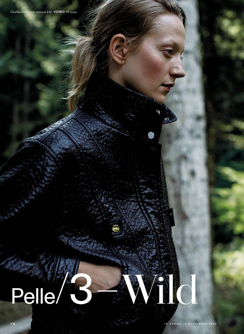 Model wearing a textured black leather jacket outdoors with trees in the background for iO Donna editorial