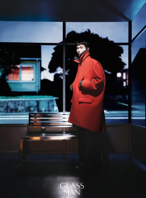 Model wearing a bright red winter coat standing inside a bus shelter at night for Glass Man China