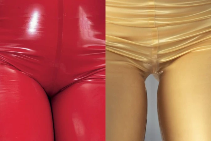 Close-up portrait featuring a person wearing glossy red latex pants alongside a person in metallic gold latex.