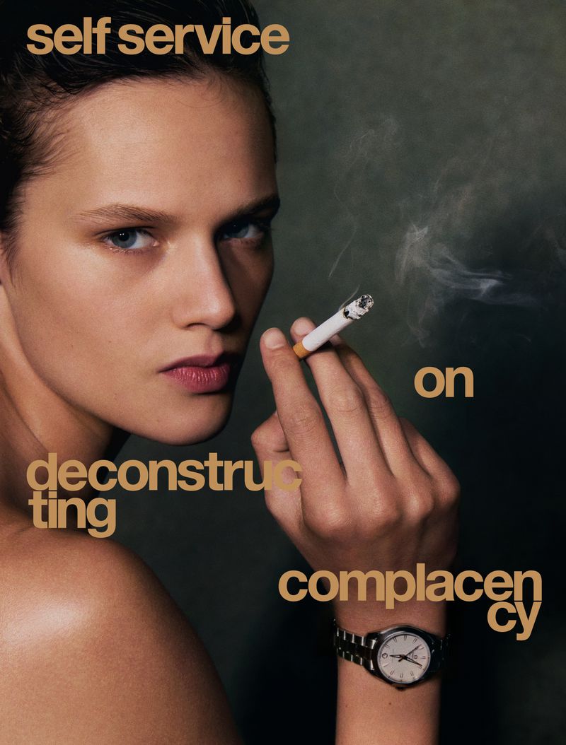 Close-up portrait of a woman holding a lit cigarette with a silver watch visible on her wrist against a dark moody background