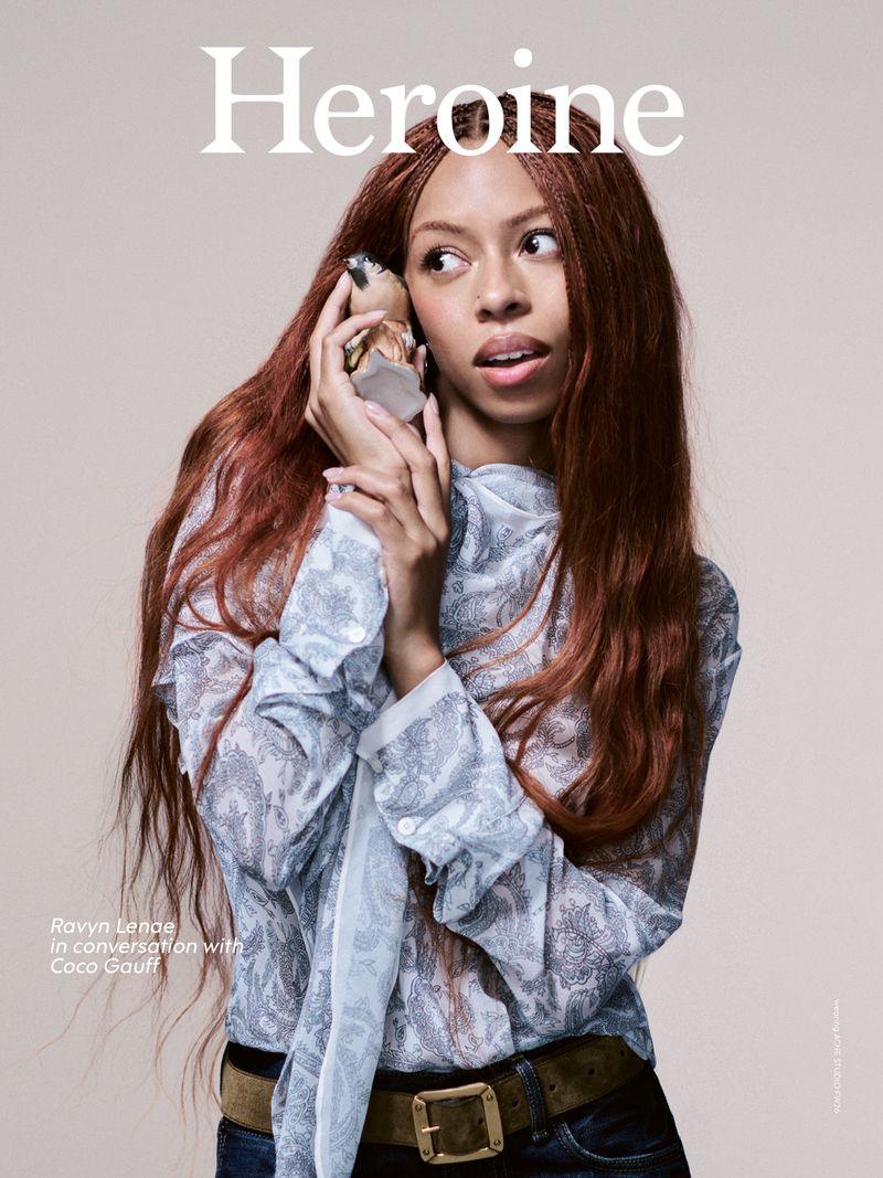 Ravyn Lenae holding a small ceramic bird to her ear against a plain backdrop for Heroine Magazine Issue 25