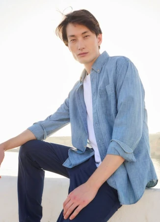Model Joseph Norris in a light blue denim shirt and dark trousers outdoors for Walbusch Show Your Style by photographer Tina Luther
