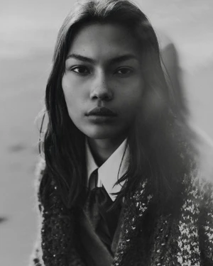 Portrait of a model wearing a white shirt and textured patterned coat