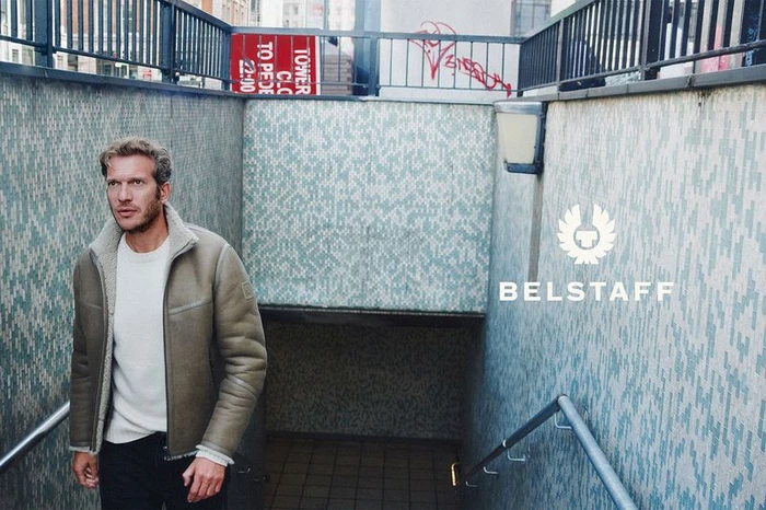Man wearing a shearling-lined leather jacket walking up tiled steps for Belstaff FW'26 campaign