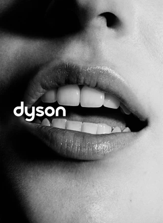 Close-up monochrome portrait focusing on parted lips and teeth with the Dyson logo overlaid.