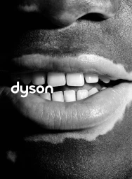 Close-up monochrome portrait focusing on lips and teeth with visible skin pigmentation variations, featuring Dyson branding.