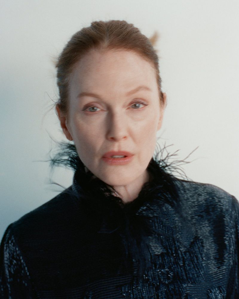 Julianne Moore wearing a black feathered high-collar top against a light background for Harper's Bazaar