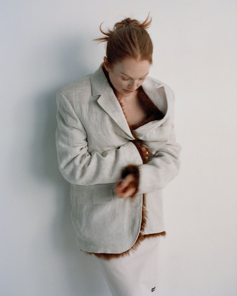 Julianne Moore wearing an oversized cream blazer with brown fur trim against a plain white wall