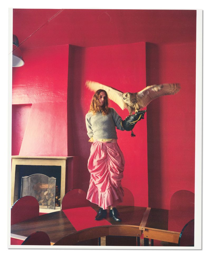 Model Roxane Plaza holding an owl in a red room for American Vogue, photographed by Pablo Di Prima.