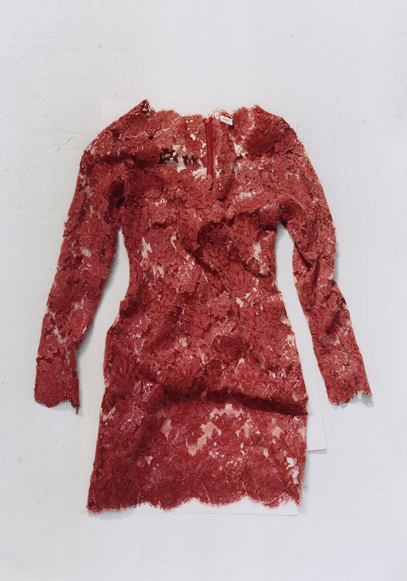 Red lace dress laid flat on a white surface for Pop Magazine editorial