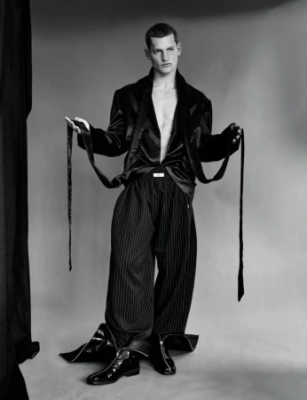 Monochrome fashion portrait of male model Ivo Pelleboer holding black satin jacket ties for Esquire Portugal.