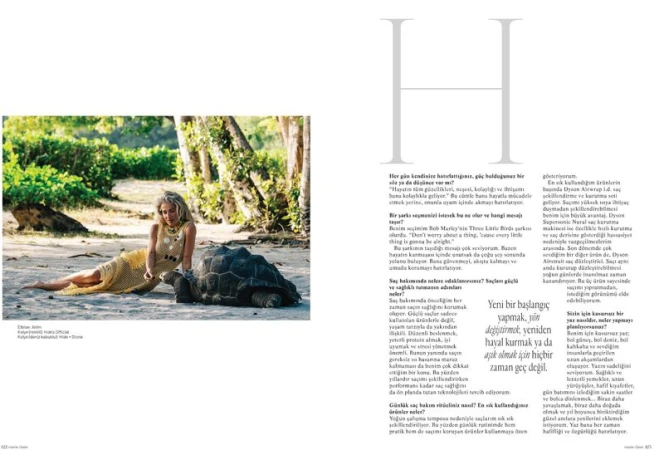 Woman in yellow crocheted dress reclining on a sandy beach next to a giant tortoise in an editorial magazine layout