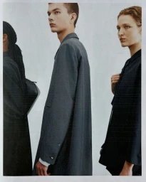 Three models wearing dark tailored garments posed against a plain light background for Jil Sander Spring Summer 2027