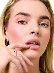 Close up beauty portrait of a woman touching her lip with a ring on her finger against a light background