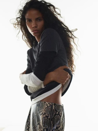 Model Josefa Santos in a layered dark top and snakeskin skirt against a bright white background for Harper's Bazaar France.
