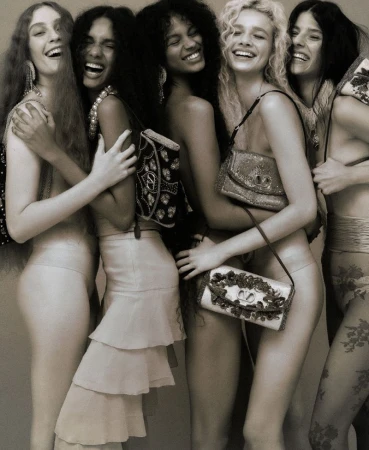 Five models laughing together in a tight embrace carrying embellished shoulder bags for Harper's Bazaar Brazil Debut