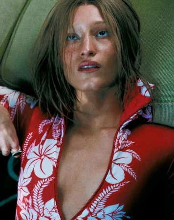 Model wearing a red and white floral top reclining against a green textured background for Harper's Bazaar Brazil