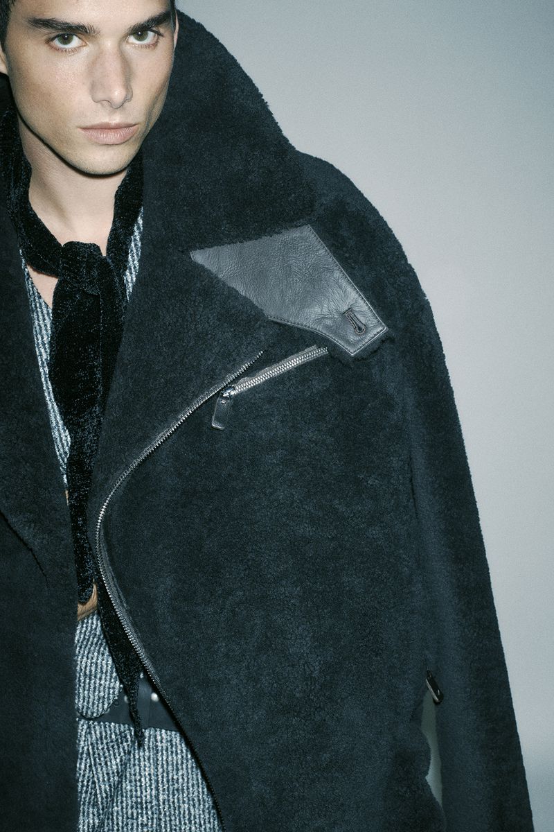 Portrait of a man wearing a dark textured shearling jacket and patterned shirt for Numero Netherlands by Simone Paccini.